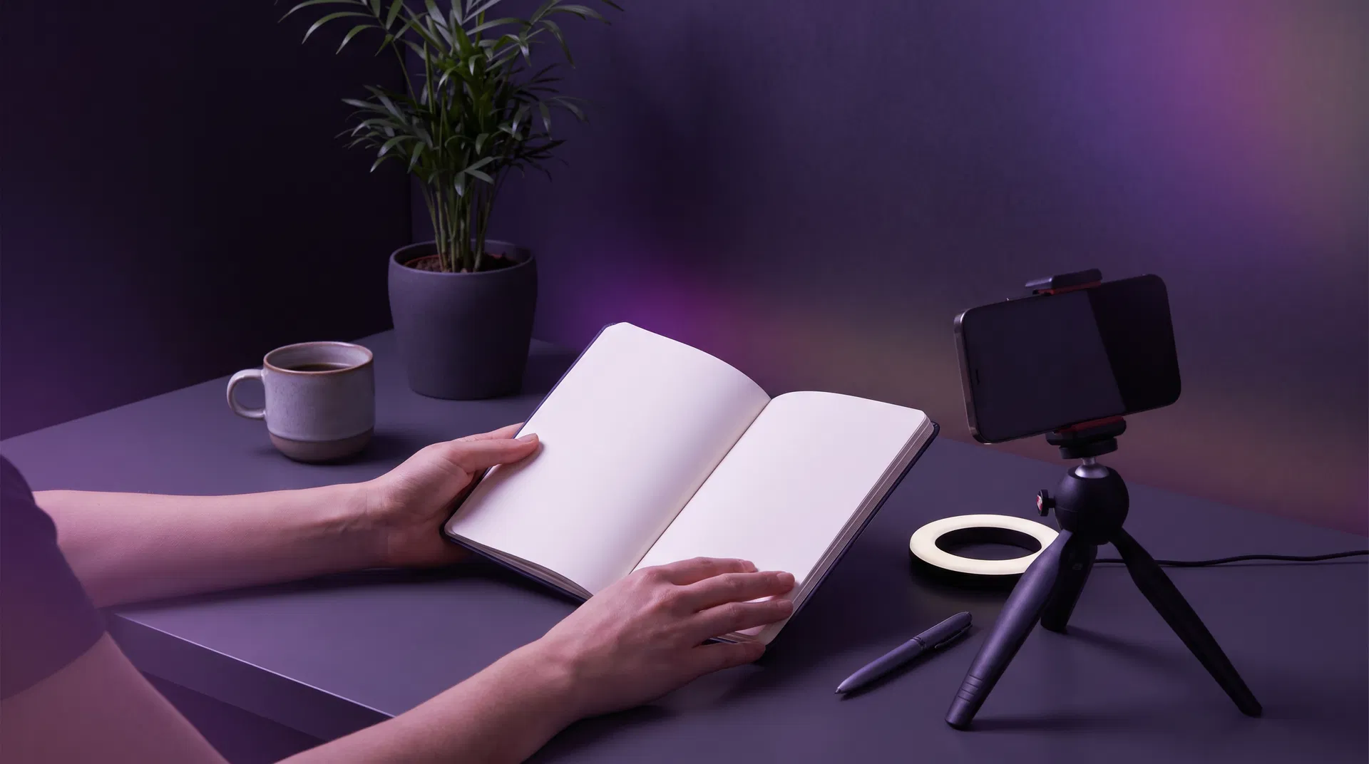 Persona empezando en UGC desde cero con smartphone y cuaderno de notas para planificar su estrategia de contenido